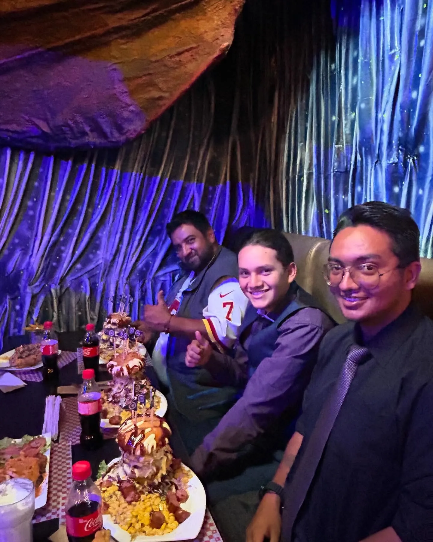 Grupo de amigos celebrando con comida compartida en La Cueva del Pirata